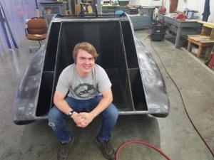 Industrial design major and Raleigh native John Lalevee poses with the unfinished solar vehicle, which he helped design during the 2017–18 year. Photo submitted